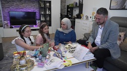 Eine Frau und ein Mann sitzen am Tisch mit zwei Kinder am Opferfest 2026