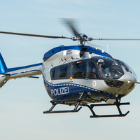 Ein Polizeihubschrauber mit Pilot, der sich in der Luft befindet.