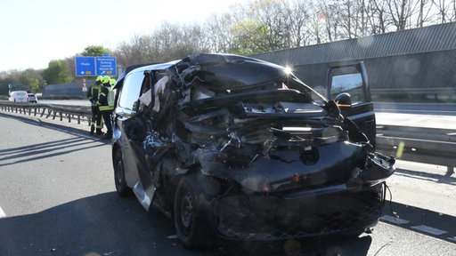 Eines der verunfallten Autos steht stark demoliert auf der Autobahn