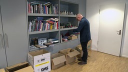 Markus Lewe steht vor mehreren Umzugskartons in seinem Büro 