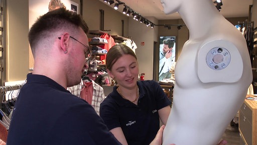 Zwei Azubis arbeiten an einer Schaufensterpuppe