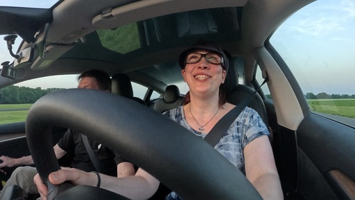 Eine Person sitzt am Lenkrad eines Autos