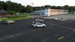 Mehrere Autos parken auf einem Flugplatz