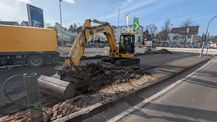 Inklusive Bagger beginnt die Sanierung einer Straße.