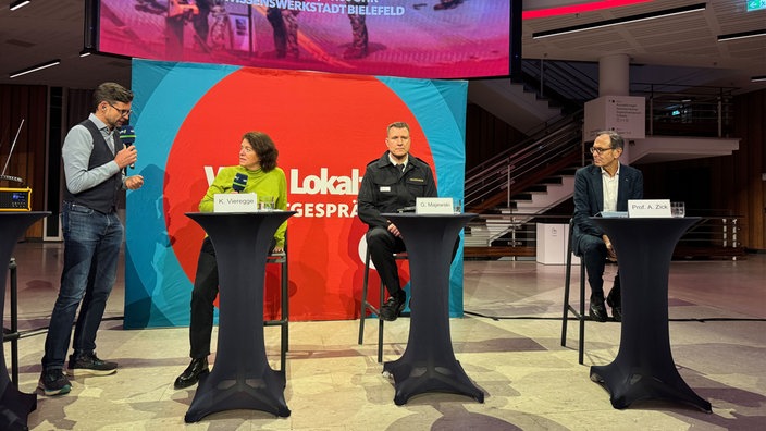 Moderator Ralph Erdenberger diskutierte mit (v.l.) Kerstin Vieregge aus dem Verteidigungsausschuss, Gordon Majewski von der Feuerwehr Bielefeld und Konfliktforscher Andreas Zick.