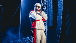 Der Rapper Sido steht performend mit Mikrofon auf der Bühne. 