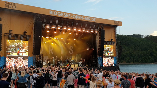 Die Biggesee Open-Air-Bühne, auf der performed wird. Davor stehen viele Menschen, die zuschauen.