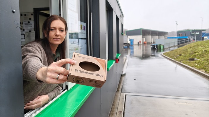 Eine Batteriesammelbox wird ins Bild gehalten