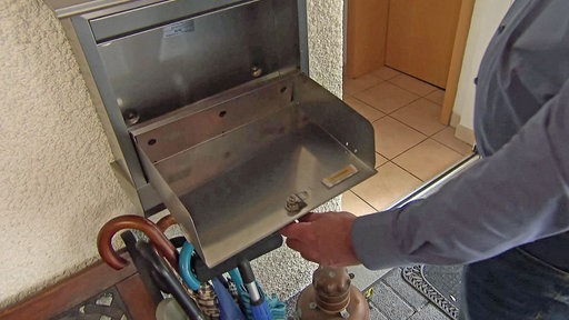 Wolfgang Menzebach öffnet seinen leeren Briefkasten