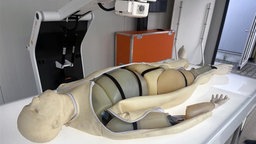 Crashtest-Dummy auf einer Krankenliege