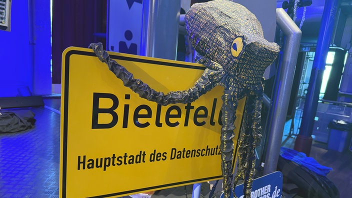 Ein Daten-Krake auf dem Ortsschild von Bielefeld