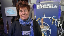Eine Frau steht vor dem Big Brother Award