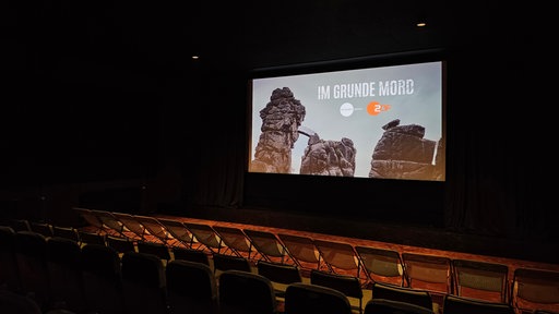 Im Kinosaal ist auf einer Leinwand der Krimi mit ZDF-Logo zu sehen