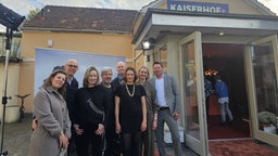 Mehrere Menschen stehen vor einem Kino-Plakat, vor dem Detmolder Kaiserhof-Kino