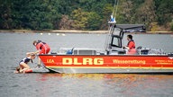 Ein Mädchen steigt auf ein DLRG Rettungsschiff auf dem Wasser.