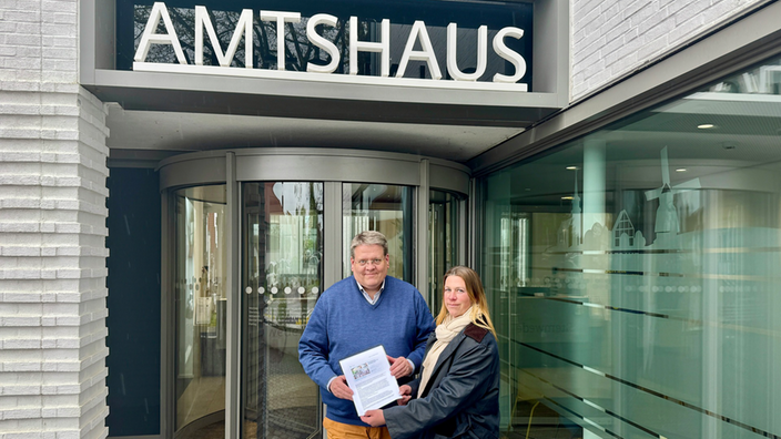 Sarah Stücker vom Waldfrieden Kultur e.V., dem Organisator des Festivals, überreicht Bürgermeister Kai Abruszat eine Petition zur Rettung des Festivals.
