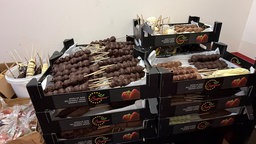 Mit Schokolade überzogene Früchte am Stieß in Kisten