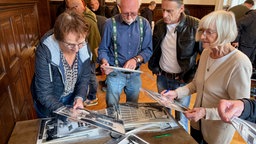 Vier Personen schauen sich Fotos an