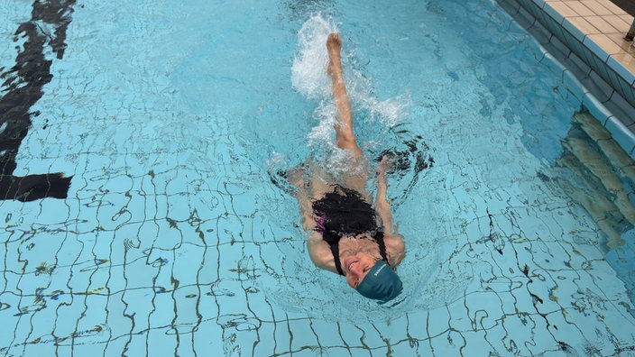 Eine Rückenschwimmerin zur Freibaderöffnung