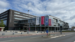 Ein Gebäude mit blauen und roten Flaggen davor.