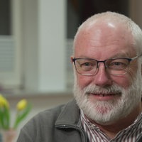Zu sehen ist ein Mann der freundlich in die Kamera lächelt