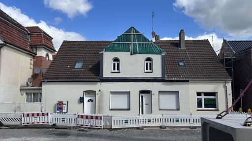 Die Vorderseite eines Hauses mit Baugerüst im Giebel 