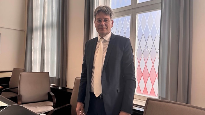Dr. Lambert Löer steht vor einem Fenster