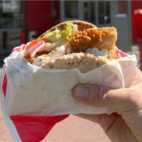 Eine Hand die den neuen "Krispy Kebab" von KFC hält