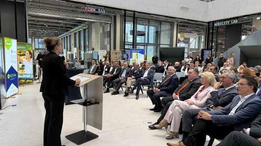 NRW Wirtschaftsministerin hält eine Rede auf der Bühne für KI im Handwerk
