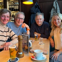 Zwei Frauen und zwei Männer sitzen an einem Tisch und schauen in die Kamera. Vor ihnen steht jeweils ein Glas Bier.