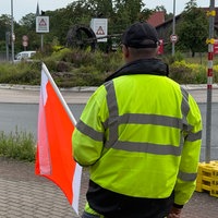 Brücken-Warnposten Egon Hasse hält mit einer Flagge den auf ihn zufahrenden LKW vor der Baustelle der Eisenbahnbrücke in Lügde an