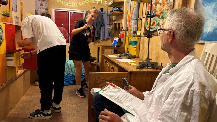 Teilnehmer und Teilnehmerinnen von Lemgo vs Wild bereiten sich in einem Zimmer vor