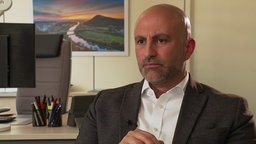 Ein Mann, Ali Doğan, beim Interview mit dem WDR in seinem Büro.