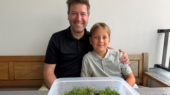 Vater und Sohn vor einem Rasenstück des SC Paderborn