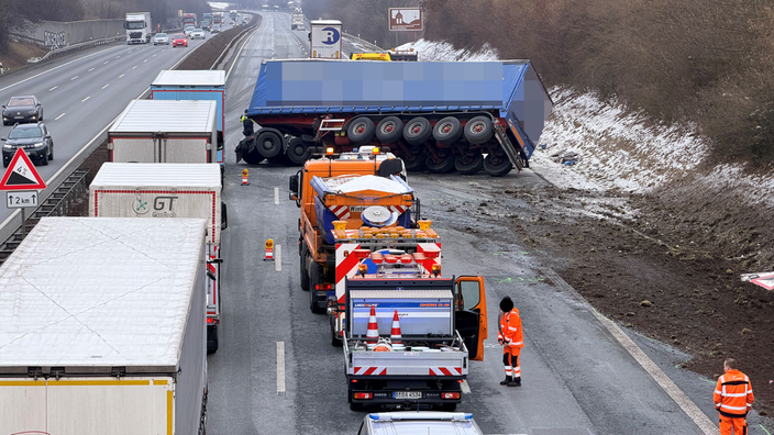 Nach dem Unfall auf der A2 liegt der Anhänger des Lkw quer über der Fahrbahn. Räumungsfahrzeuge und Polizei sind ebenfalls vor Ort.