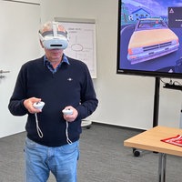 Ein Mann hat eine VR-Brille auf und bedient Controller