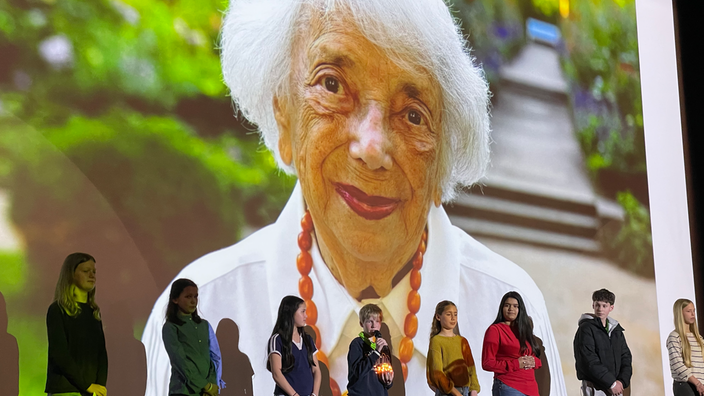 Schülerinnen und Schüler der Schule vor einem Bild von Margot Freidländer