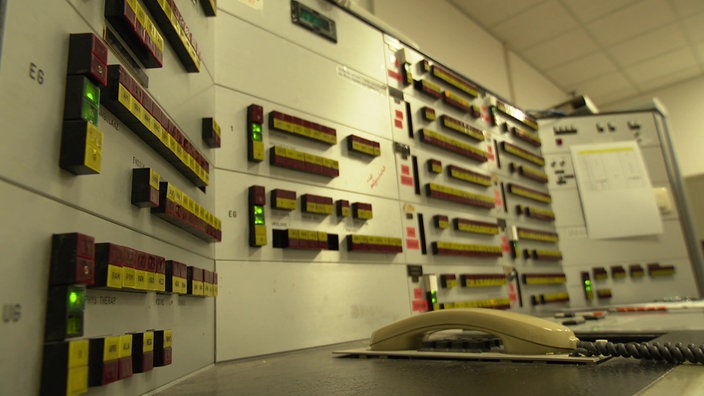 Eine technische Schaltzentrale in einer der Mühlenkreiskliniken. Viele Schalter und Knöpfe an den Wänden und ein Telefon auf dem Schreibtisch.