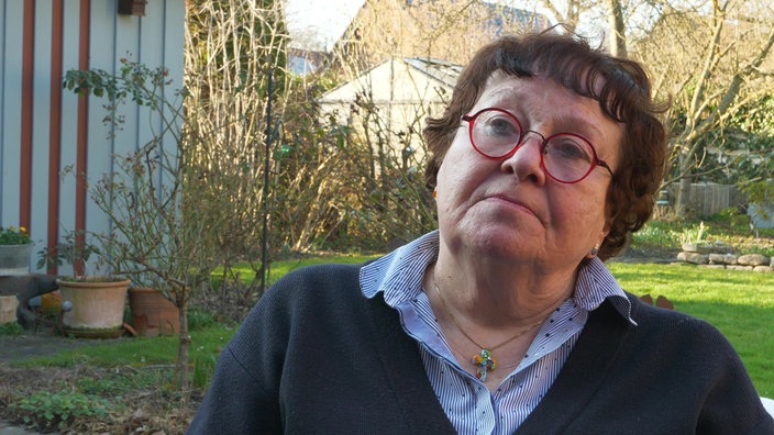 eine Frau vor einem Garten