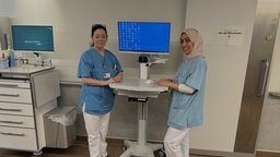 Zwei Klinikmitarbeiterinnen an einem Stehtisch