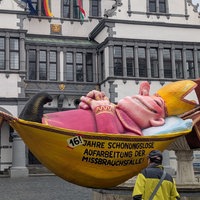 Ein Jacques Tilly Wagen sorgt für Aufsehen vorm Paderborner Rathaus. Der Wagen zeigt einen Bischof der in einer Hängematte ausruht. Aufschrift: 16 Jahre schonungslose Aufarbeitung der Missbrauchsfälle.