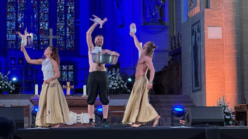 Trio tanzte bei der Performance mit in Windeln gewickelten Tiefkühlhähnchen durch den Altarraum. 