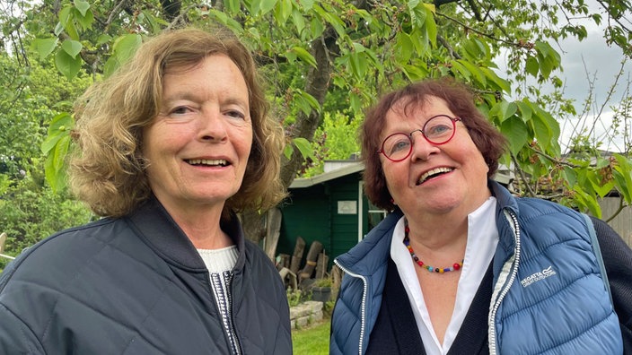Zwei Frauen der Initiative Maria 2.0 in einem Garten in Münster