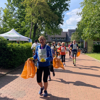 Teilnehmer:innen mit Mülltüten beim Lauf 