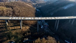 Die Luftaufnahme zeigt die riesige Friedensbotschaft «Lasst uns Brücken bauen» auf der gesperrten Rahmedetalbrücke der Autobahn 45 bei Lüdenscheid (Nordrhein-Westfalen).