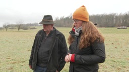 Ein Mann und eien Frau stehen auf einer Wiese