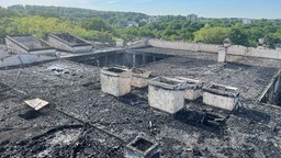 Das schwarz verkohlte Dach eines ausgebrannten Gebäudes von oben