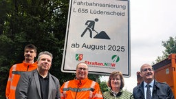 Fünf Menschen, darunter Verkehrsminister Heinz Krischer, stehen vor dem Schild, dass die Baustelle an der L655 ankündigt. 