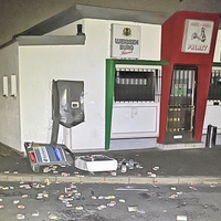 Nächtliche Aufnahme eines gesprengten Zigarettenautomaten vor einer Bude 