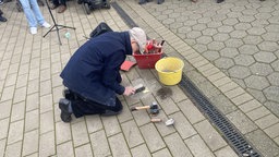Mann setzt Stolpersteine ein